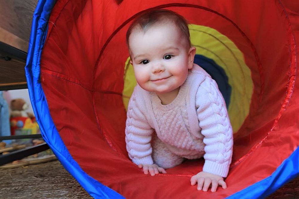 Bé 1 tuổi đang bò qua đường hầm tự tạo một cách thích thú