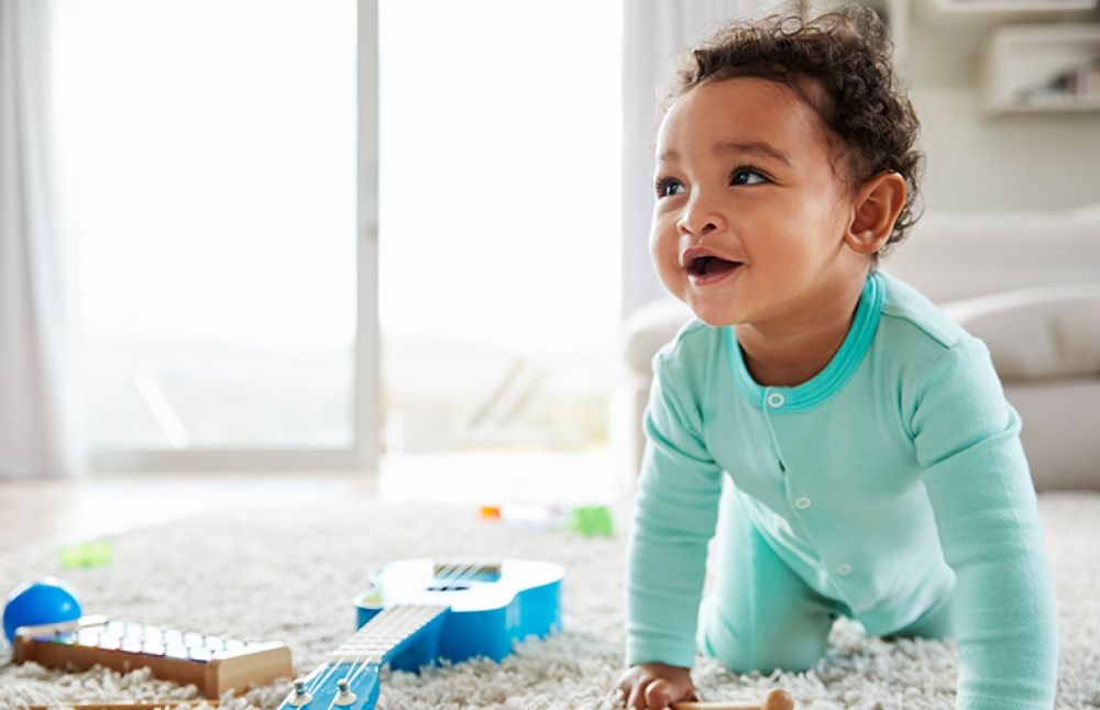 Bé 1 tuổi đang tập trung tìm kiếm đồ chơi bị giấu dưới khăn