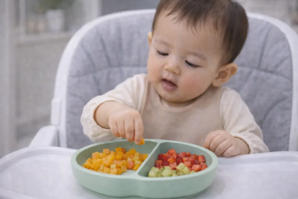 Cắt trái cây hình hạt lựu nhỏ giúp bé 9 tháng rèn luyện kỹ năng vận động tinh và khả năng bốc nhón linh hoạt.