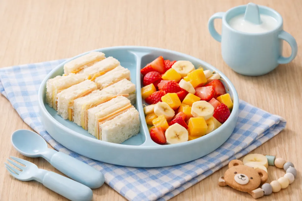 Bánh sandwich mềm và trái cây cắt nhỏ là lựa chọn bữa sáng nhanh gọn, giúp bé rèn luyện kỹ năng bốc nhón.